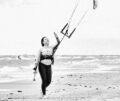 Nadja Knauder mit Kiteboard unter dem Arm am Strand - Kite2Connect